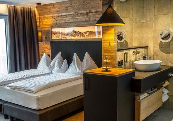 Doppelbett und ein teil des Bads im Appartement Anzenberg