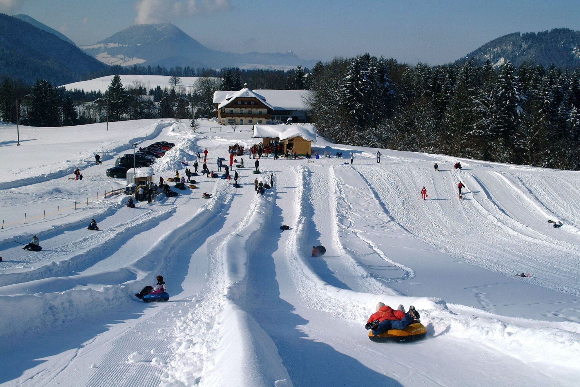 At snow tubing in Faistenau, several tracks are prepared for tires. You ride down a hill on tires of different sizes.